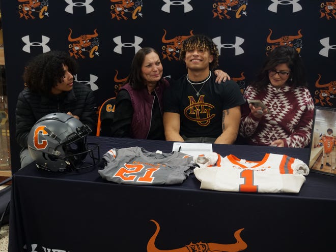 Caprock's Jamel Acosta-Lewis (seated center right) signed his National Letter of Intent to play football at Colorado Mesa on Thursday, February 9, 2023 at Caprock High School.