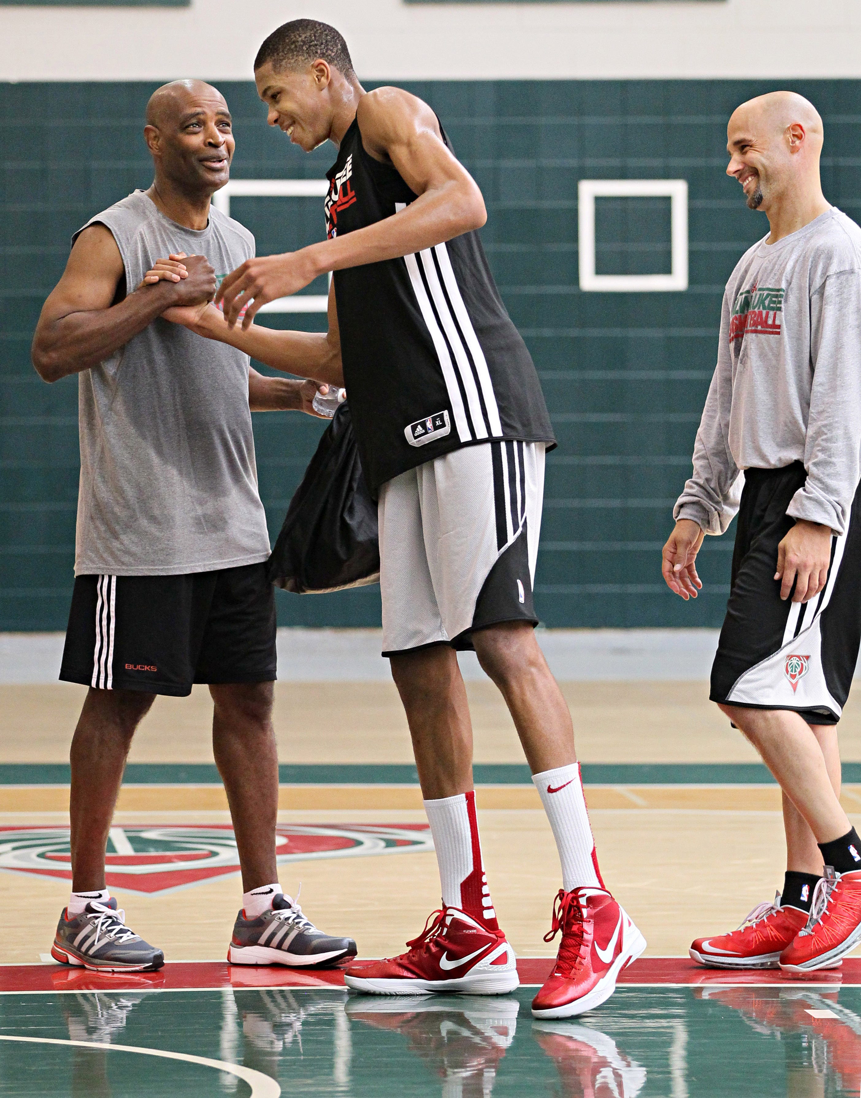 Rookie Giannis Antetokounmpo, the Bucks' first-round pick in 2013, shakes hands with coach Larry Drew as assistant Josh Oppenheimer looks on during Antetokounmpo's first training camp.