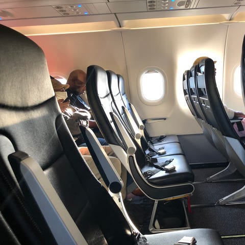 An empty row of seats with seatbelts visible on a 