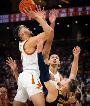 Texas forward Timmy Allen gets his shot off over West Virginia guard Erik Stevenson during the Longhorns' 94-60 win at Moody Center on Saturday. Allen and the Longhorns will travel Monday to Lubbock, where Texas Tech has won its last two home games against ranked Big 12 foes.