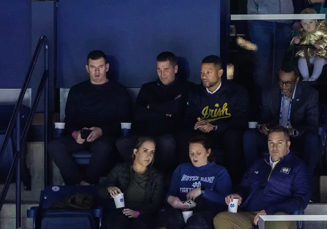 Notre Dame offensive coordinator candidate Andy Ludwig, second from left (top row), takes in a Notre Dame hockey game Friday, Feb. 10 at the Compton Family Ice Arena in South Bend. Seated next to him is Irish tight ends coach Gerad Parker (left) and ND head football coach Marcus Freeman (right). Ludwig is currently the OC at Utah.