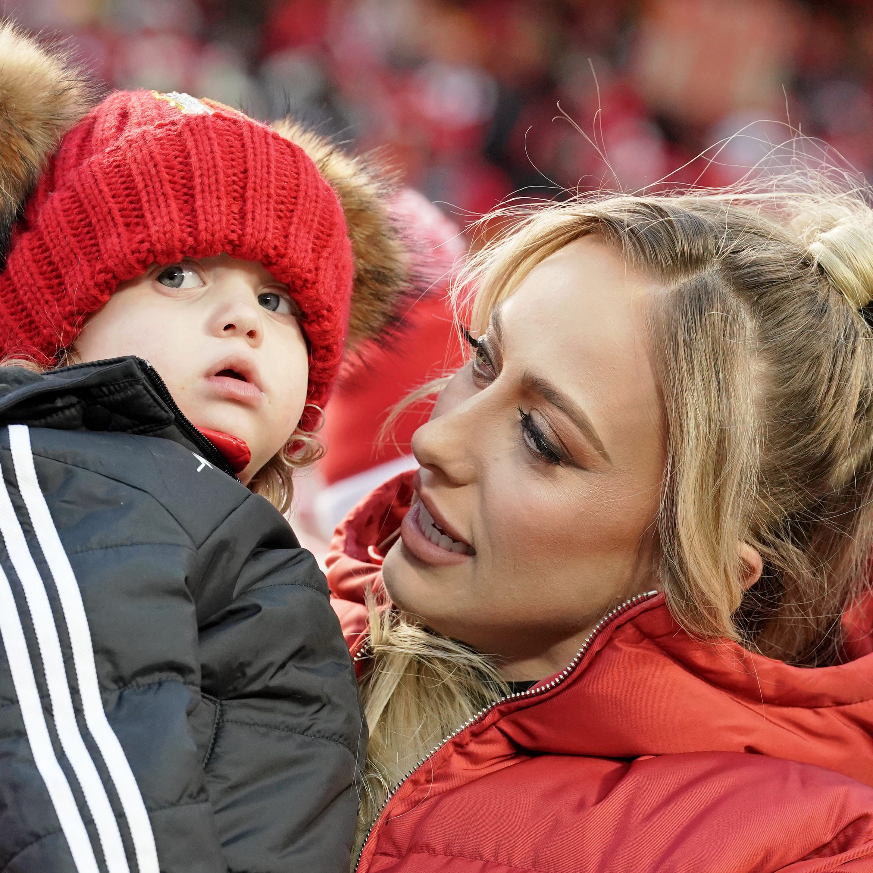 Brittany Mahomes holds up Sterling Skye as they watch warmups before the AFC championship game between the Kansas City Chiefs and the Cincinnati Bengals at GEHA Field at Arrowhead Stadium.