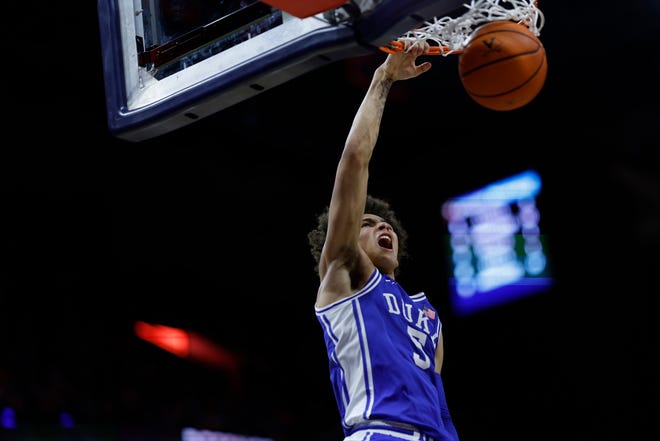 Feb 11, 2023; Charlottesville, Virginia, USA; Duke Blue Devils guard Tyrese Proctor (5) dunks the ball as Virginia Cavaliers guard Armaan Franklin (4) looks on in the first half at John Paul Jones Arena. Mandatory Credit: Geoff Burke-USA TODAY Sports