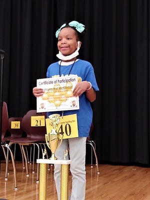 Spelling Champion Ashlynn-Kai McClinton, a fifth grader at Raines Elementary, displays her winning certificate and trophy during Saturday’s Hinds County Spelling Bee competition.