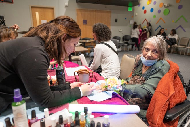 Dorothy Young, right, has her nails painted by IntelliTec College student Faith Frazier at the "Night to Shine" event on Frday, Feb. 10, 2023.