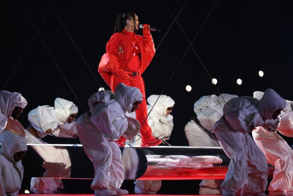 Rihanna performs with dancers dressed in white jumpsuits surrounding her.&nbsp;