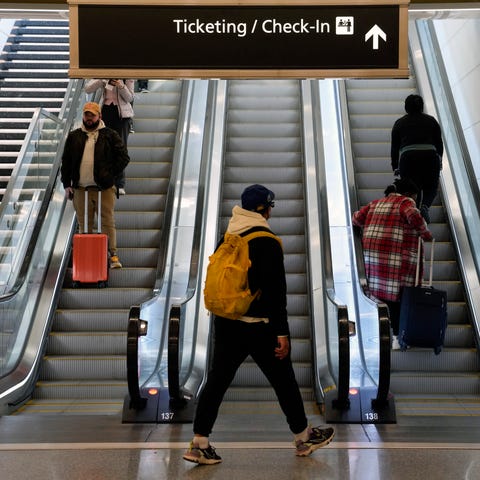 Travelers ride escalators in a terminal at Ronald 