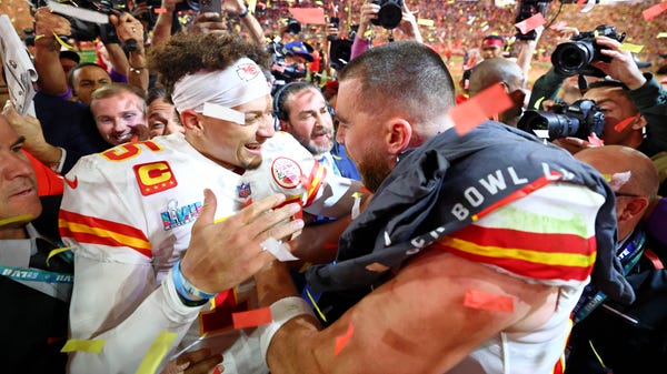 Kansas City Chiefs quarterback Patrick Mahomes (left) celebrates with tight end Travis Kelce (right) after winning Super Bowl 57.