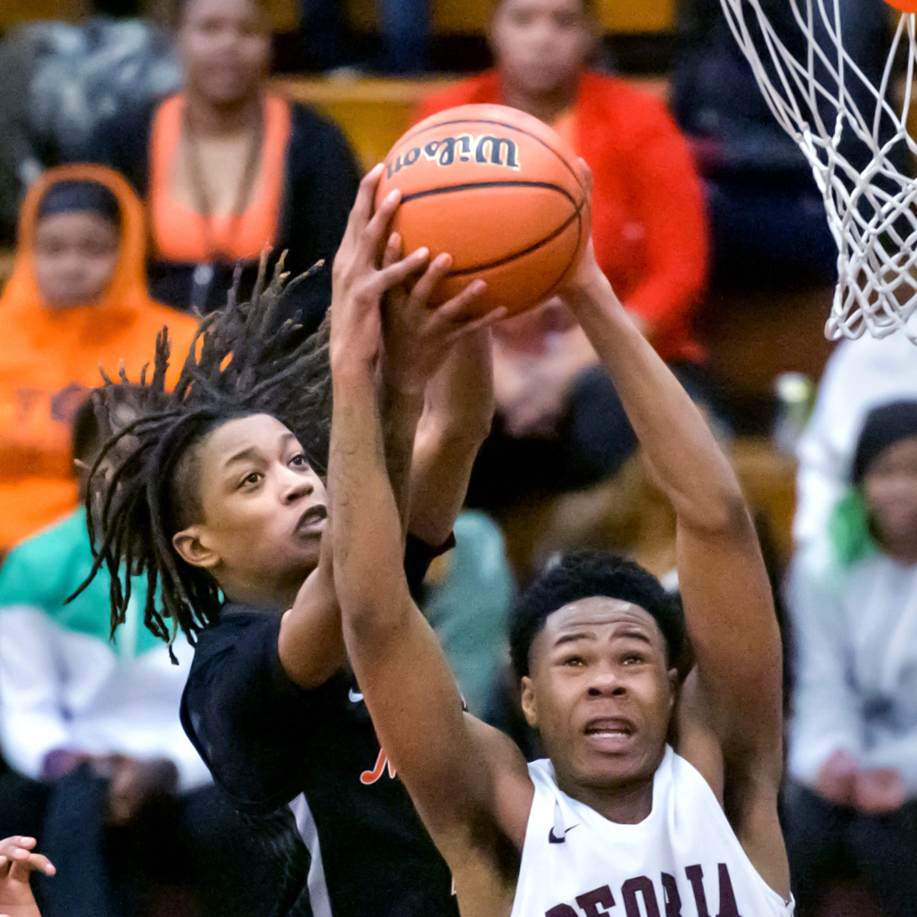 Peoria High's LeShawn Stowers (21) and Manual's Dietrich Richardson battle for a rebound in the second half Saturday, Feb. 14, 2023 at Peoria High School. The Rams rallied to defeat the Lions 66-61.