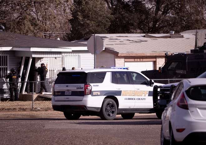 Lubbock County Sherriff's Office SWAT takes a suspect into custody after a standoff at 61st Street and Avenue Q on Wednesday.