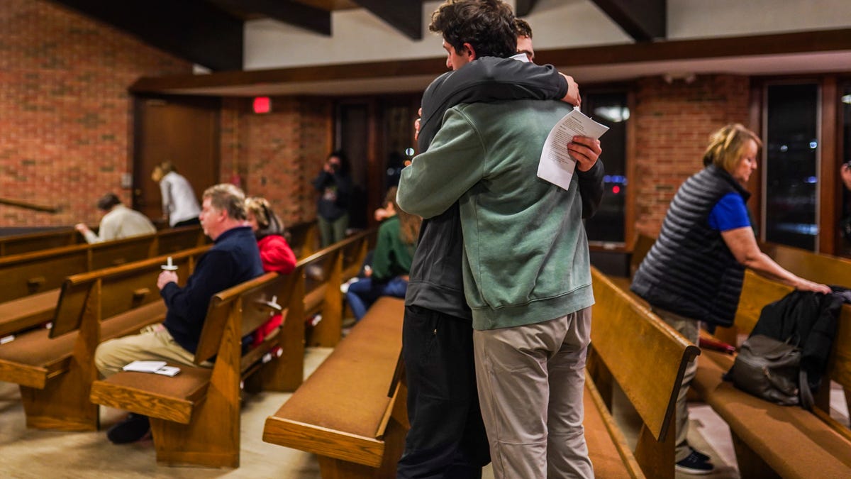 People hug at the end of a vigil held at Eastminster Presbyterian Church in East Lansing on Tuesday, February 14, 2023, in memory of the students shot and killed during a mass shooting at Michigan State University.