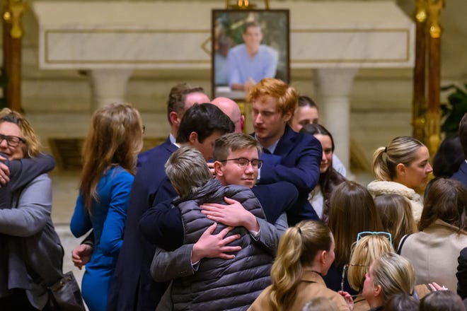 Teman dan pendukung saling menghibur selama upacara peringatan untuk Brian Fraser di St Paul on the Lake Catholic Church, di Grosse Pointe Farms, 14 Februari 2023. Fraser diidentifikasi sebagai salah satu dari tiga mahasiswa yang terbunuh dalam penembakan massal di kampus Michigan State University , Malam Senin.