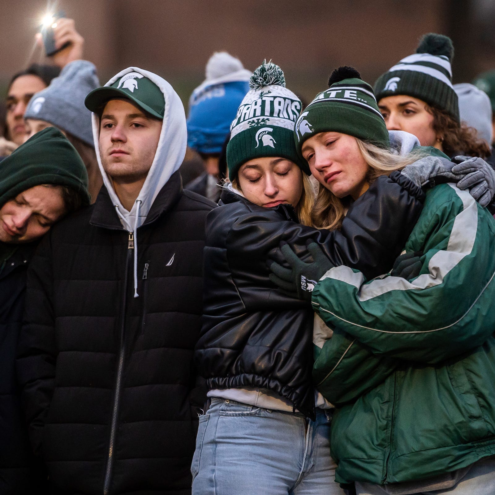 People comfort each other during a vigil at The Rock on the Michigan State University campus in East Lansing on Wednesday, February 15, 2023, to honor and remember the victims of the mass shooting that happened on the MSU campus that left three dead and multiple others injured. 
