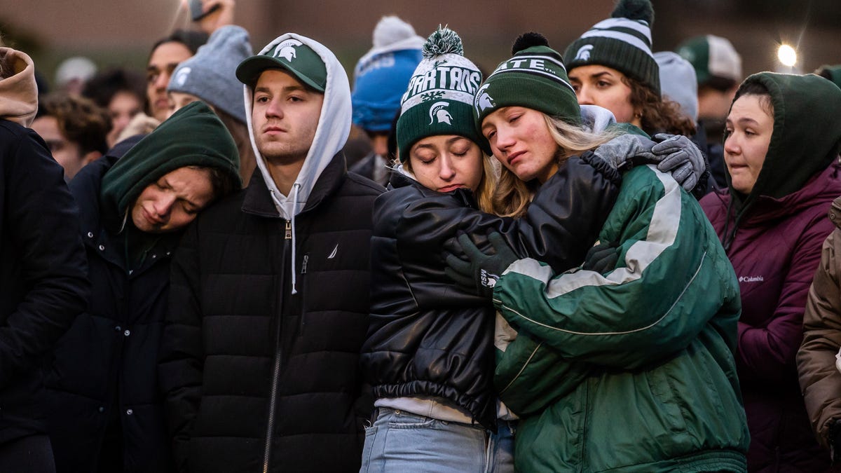 People comfort each other during a vigil at The Rock on the Michigan State University campus in East Lansing on Wednesday, February 15, 2023, to honor and remember the victims of the mass shooting that happened on the MSU campus that left three dead and multiple others injured. 