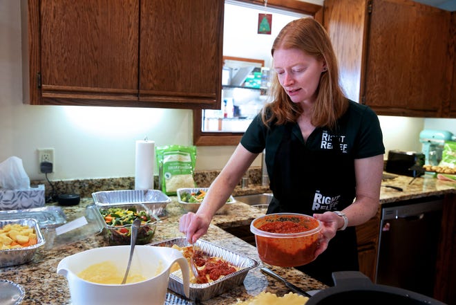 Hollie Mealy prepares lasagna for Kathy’s House, a hospital guest house that support guests receiving care at area hospitals. On Monday, Feb. 13, 2023 at her Menomonee Falls home, Mealy was also preparing  fruit and vegetable salads along with chocolate chip cookies.