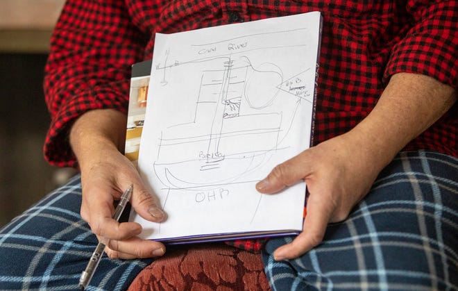 Marco Díaz-Muñoz, 64, an assistant professor at Michigan State University, holds a sketch he made of how he believes the gunman gained access to his classroom, as Díaz-Muñoz sits inside his home in Lansing on Thursday, Feb. 16, 2023. 