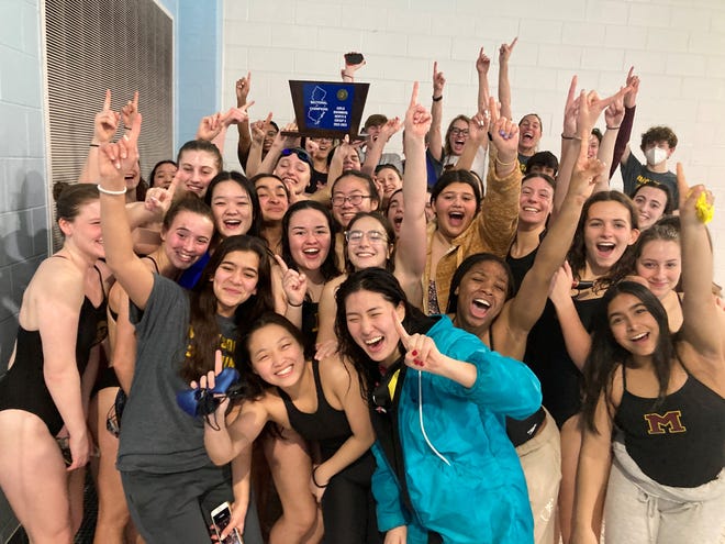 The Madison girls swim team celebrates after winning its first sectional title on Feb. 16, 2023.