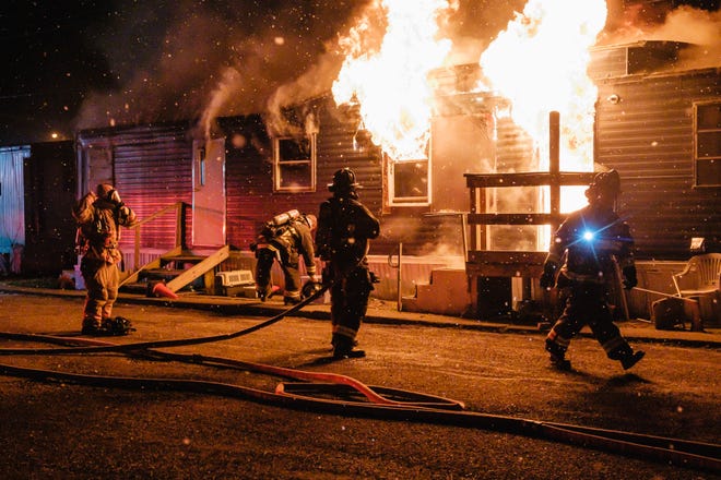 New Philadelphia firefighters work on a mobile home fire Friday on 11th Street NW in New Philadelphia.