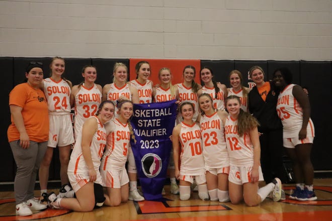 The Solon Spartans pose for a photo with their "State Qualifier" banner following Saturday's 58-44 regional final win over Mount Vernon.