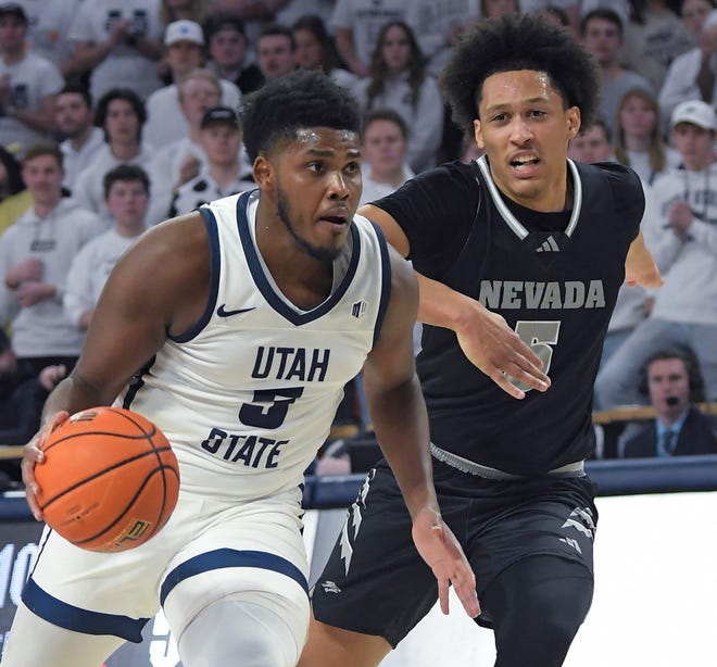 Utah State guard RJ Eytle-Rock, left, dribbles the ball as Nevada forward Darrion Williams defends during the second half of an NCAA college basketball game Saturday, Feb. 18, 2023, in Logan, Utah. (Eli Lucero/The Herald Journal via AP)