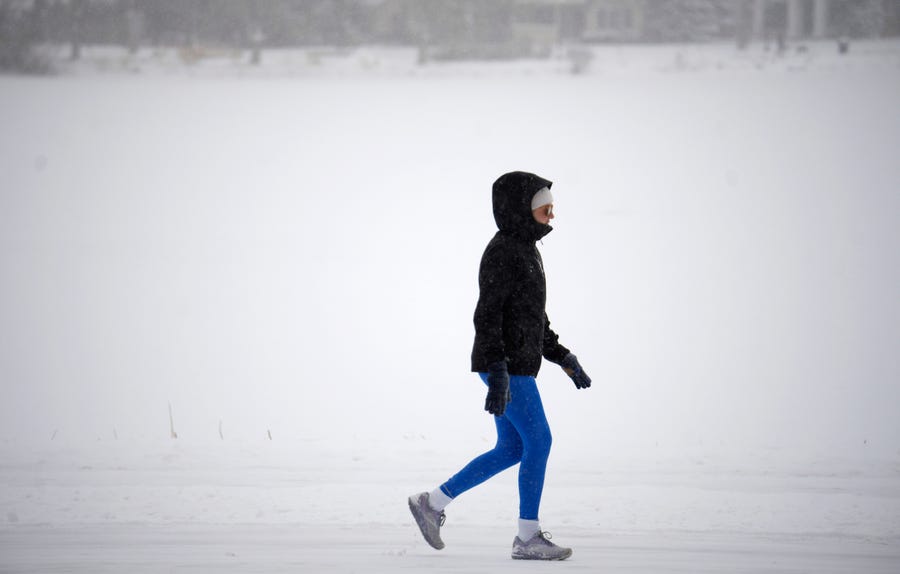 A bundled-up walker circles the path in Washington Park after a winter storm packing single-digit temperatures combined with a light snow crossed over the intermountain West Wednesday, Feb. 15, 2023, in Denver.