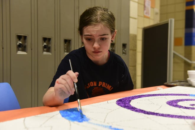 Brooklyn Lucius, a sixth-grade student at Galion Middle Schools, paints a ceiling tile during family art night at the school.