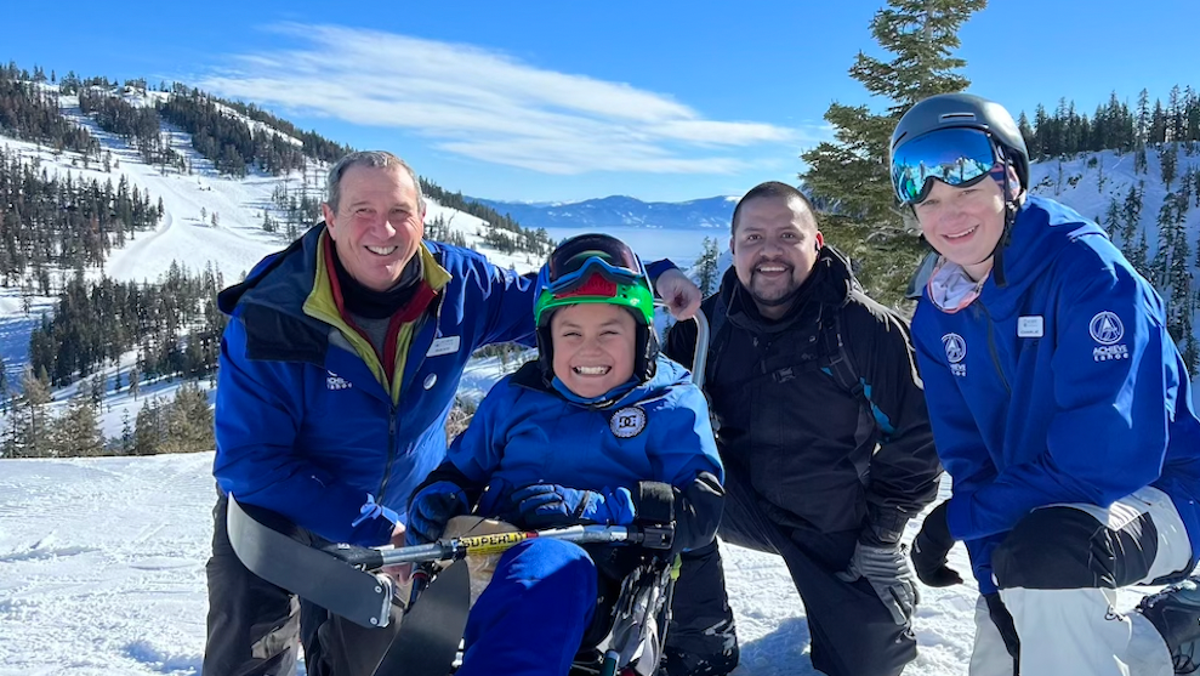 Emmanuel (second from left) is all smiles after his first lesson with Achieve Tahoe. The nonprofit lent him adaptive ski gear for his first time on the slopes since his amputation. His dad, Pablo, (third from the left) watched his lesson.