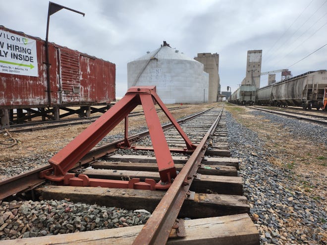 A new barrier is installed at the end of the railroad tracks near Amarillo Boulevard East on Tuesday afternoon, after a Monday morning train derailment pushed several train cars onto the roadway, blocking traffic for several hours.