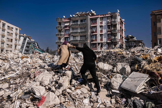February 20, 2023: A couple climbs the rubble of collapsed buildings in Antakya, southern Turkey. - A 7.8-magnitude earthquake hit near Gaziantep, Turkey, in the early hours of February 6, followed by another 7.5-magnitude tremor just after midday. The quakes caused widespread destruction in southern Turkey and northern Syria and killed more than 44,000 people.