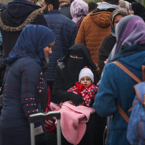 Syrians wait to cross into Syria from Turkey at th