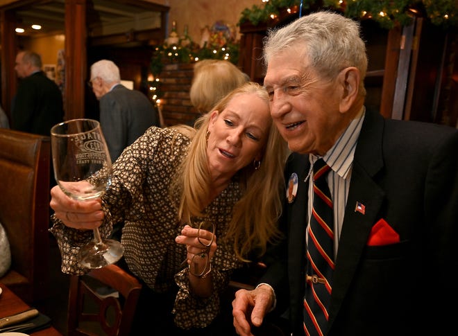 Helen Brodin of Holden shows Perry Sacco the commemorative wine glass created for his 100th birthday celebration at Dino's Ristorante on Monday.