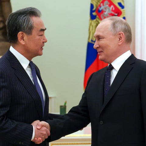 Russian President Vladimir Putin greets Chinese Co