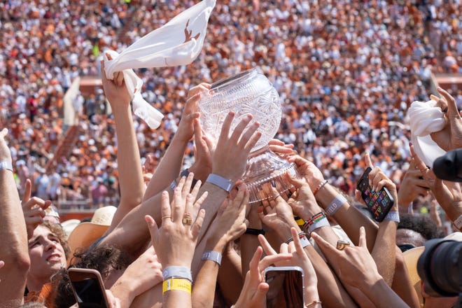 Texas athletes lift the 2022 Directors' Cup in an on-field ceremony during the Texas-Alabama game in September at Royal-Memorial Stadium. Texas has won back-to-back Directors' Cups, which go to the nation's top overall athletic program.