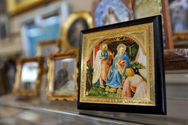 A tiny framed image of the Virgin Mary with the baby Jesus was one of many items for sale at the Queen of Angels Catholic Store in this 2012 photo.