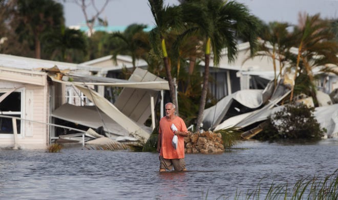Stan Pentz walks out of his Fort Myers neighborhood after Hurricane Ian made landfall Sept. 28, 2022. He survived by swimming and holding onto items around his home.