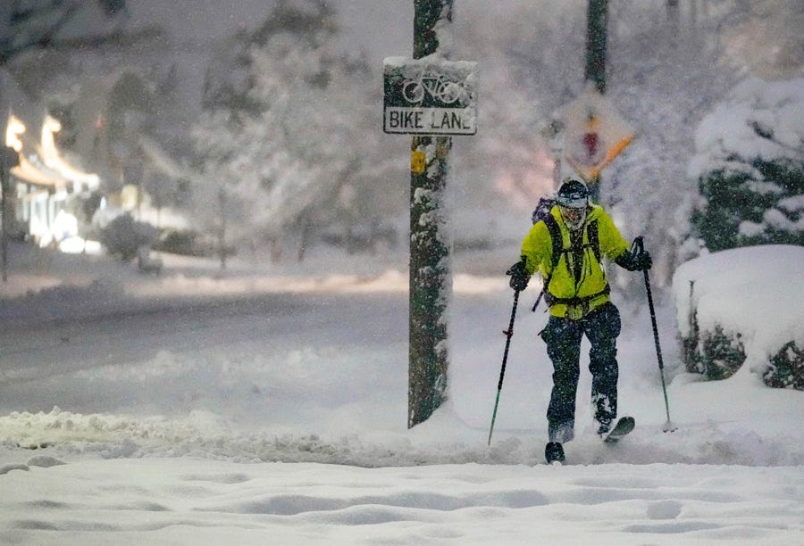 Kai Benedict commutes to his job at the VA Hospital by skis following a snow storm that blanketed the Salt Lake Valley with snow on Wednesday, Feb. 22, 2023, in Salt Lake City, Utah.  Brutal winter weather hammered the northern U.S. Wednesday with 