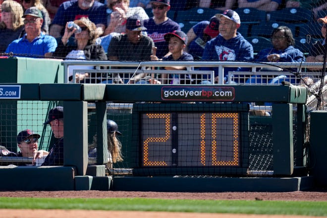 The newly installed pitch clock is lit behind the plate in the third inning of the MLB Cactus League spring training game between the Cincinnati Reds and the Cleveland Guardians at Goodyear Ballpark in Goodyear, Ariz., on Saturday, Feb. 25.