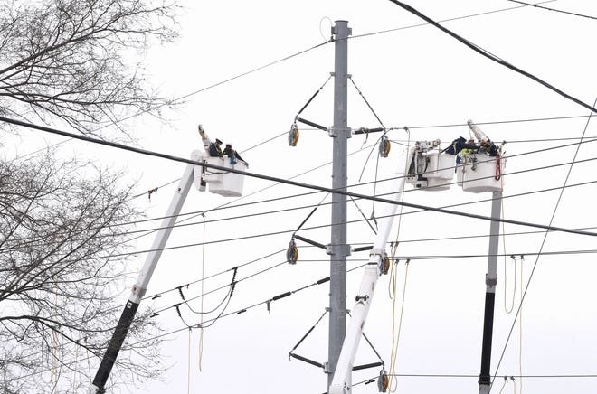 Seorang kru dari perusahaan transmisi listrik ITC Transmission bekerja di jaringan listrik pada 25 Februari di sepanjang 8 Mile Road di Ferndale.
