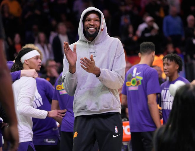 Penyerang Phoenix Suns Kevin Durant bertepuk tangan untuk rekan setim barunya selama kuartal pertama pertandingan 14 Februari 2023 melawan Sacramento Kings di Footprint Center di Phoenix.