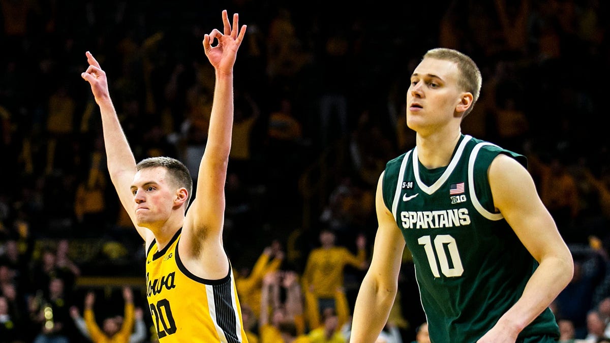 Iowa forward Payton Sandfort, left, celebrates making a 3-pointer as Michigan State forward Joey Hauser defends.