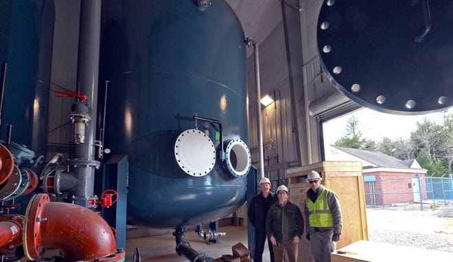 At a new PFAS treatment center in Mashpee, from left, Doug Karson, the community involvement lead for the U.S. Air Force Civil Engineer Center's remediation program at Joint Base Cape Cod, stands next to project manager Lou Baerga and quality control manager Christian Buerkle.