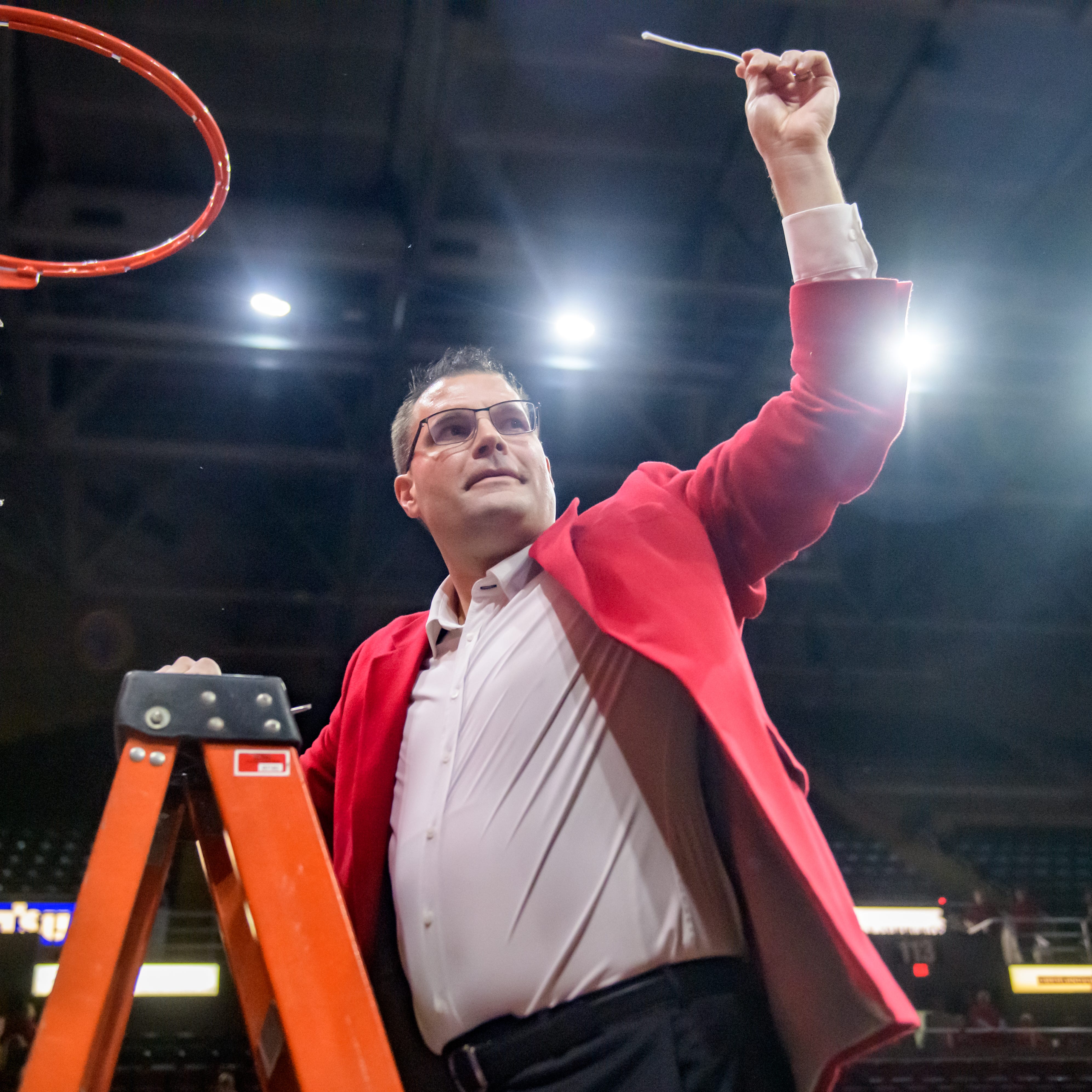 Bradley Braves head coach Brian Wardle holds up a piece of net for the crowd after cutting it down in celebration of winning the MVC championship with a 73-61 defeat of Drake on Sunday, Feb. 26, 2023 at Carver Arena.