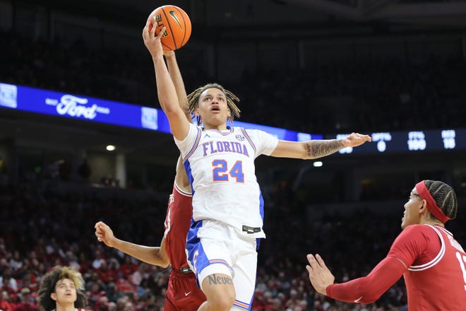 Feb 18, 2023; Fayetteville, Arkansas, USA; Florida Gators guard Riley Kugel (24) drives against Arkansas Razorbacks guards Anthony Black (0) and Jordan Walsh (13) during the first half at Bud Walton Arena. Mandatory Credit: Nelson Chenault-USA TODAY Sports