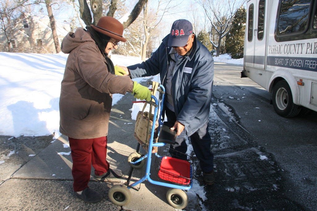 Elderly woman being assisted by a bus driver