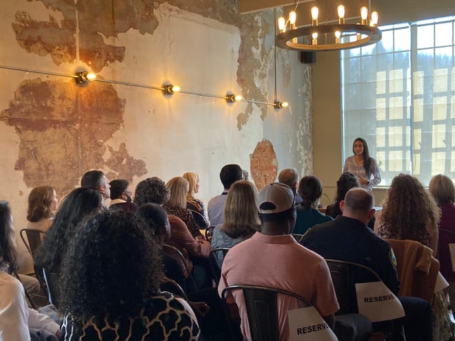 A speaker addresses the packed room at a meeting of Asheville City Council members, the Buncombe County Tourism Development Authority and the Asheville Area Chamber of Commerce on March 1, 2023.