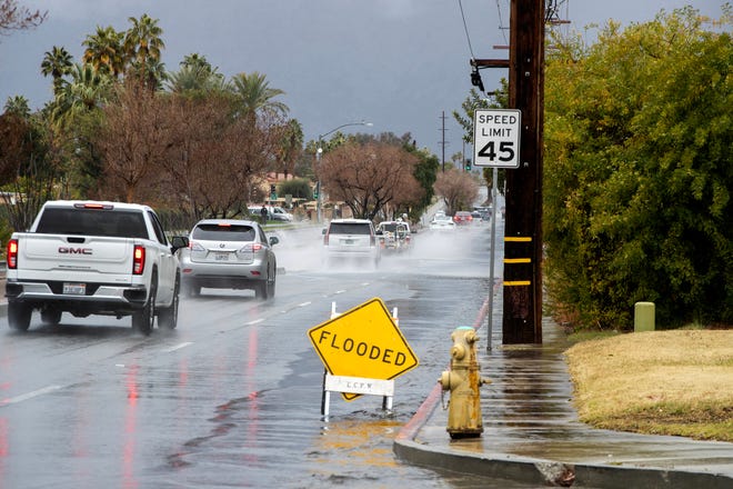 Vehicles travel along Dinah Shore Drive as rain falls in Cathedral City, Calif., on March 1, 2023.