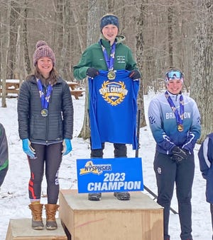 Adirondack freshman Cora Hinsdill stands on top of the podium as the winner of the state championship in the nordic ski individual race Monday. With her are second place finisher Clara Avery of Glens Falls, left, and third place finisher Emelia Jordan of Brighton.