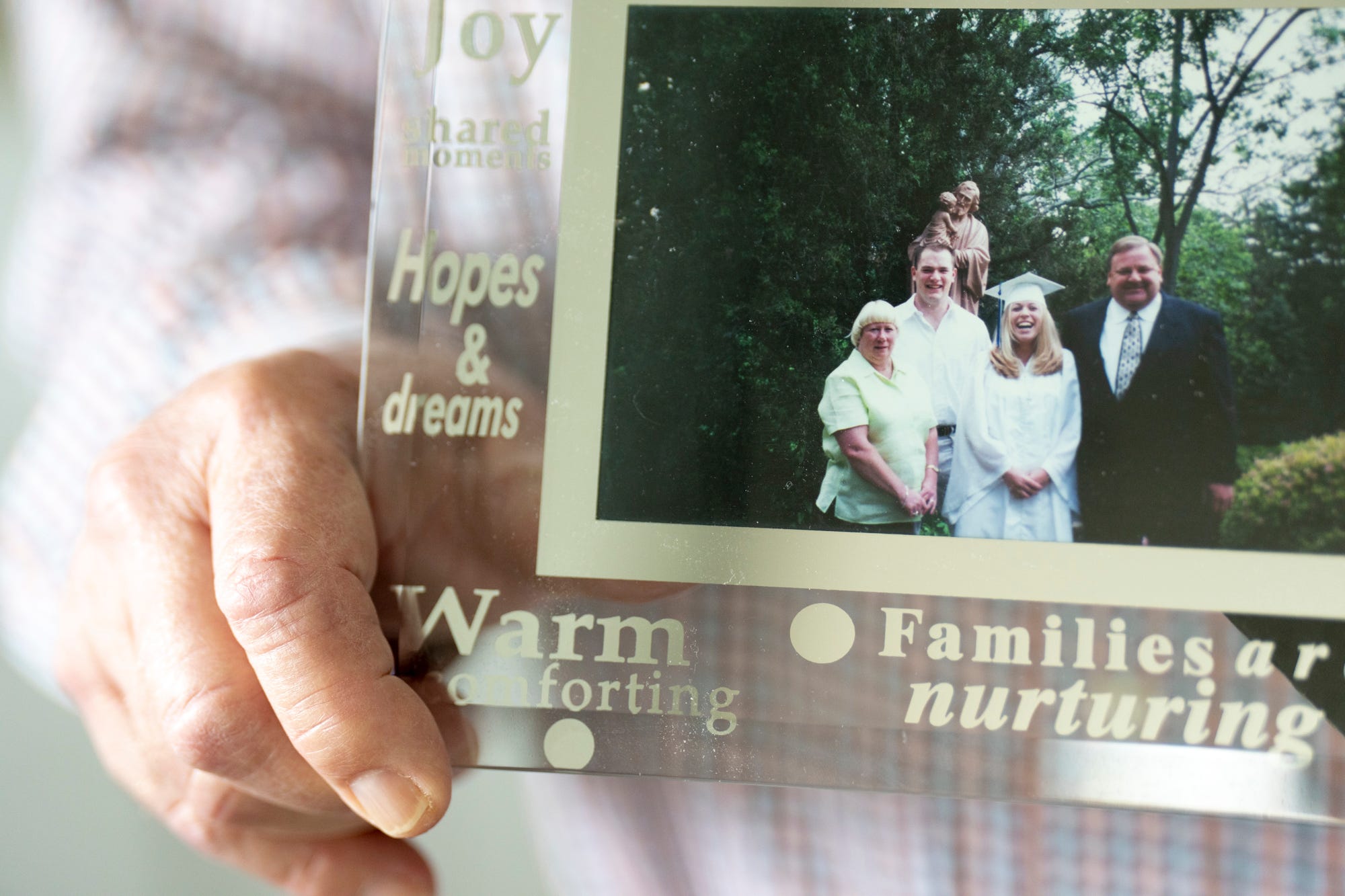 Dan Neyer holds a family portrait, from left, his wife, Chris, his son, Paul, and daughter, Kristy, taken on his daughters graduation in 2000. Paul Neyer, whose decision to come forward after almost 30 years sent Fr. Geoff Drew to prison.