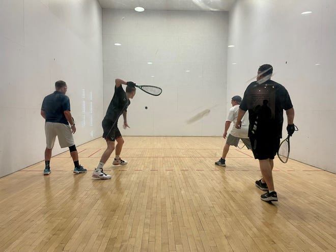 Iain Dunn, second from left, winds up during a racquetball doubles match with Tom Fuhrmann, Mike Fischer and Jonathan Dunn at Crunch Fitness in Simi Valley on Feb. 27.