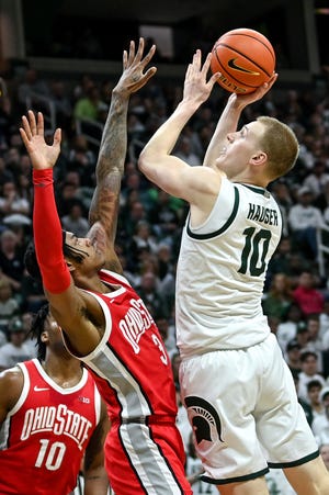 Michigan State's Joey Hauser, right, scores as Ohio State's Eugene Brown III defends during the second half on Saturday, March 4, 2023, at the Breslin Center in East Lansing.